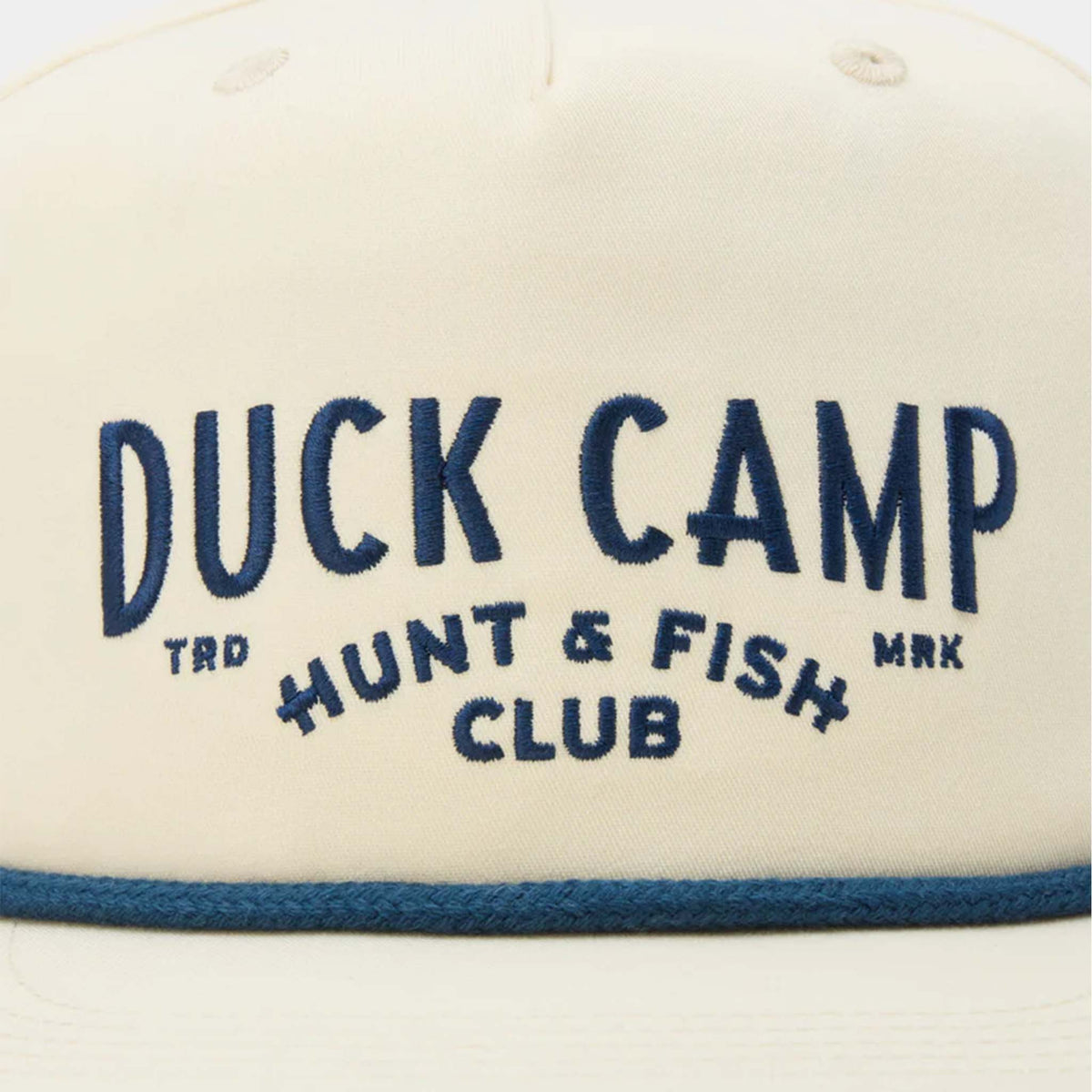 Close-up of front panel showing navy “Duck Camp Hunt & Fish Club” embroidery and blue rope trim.