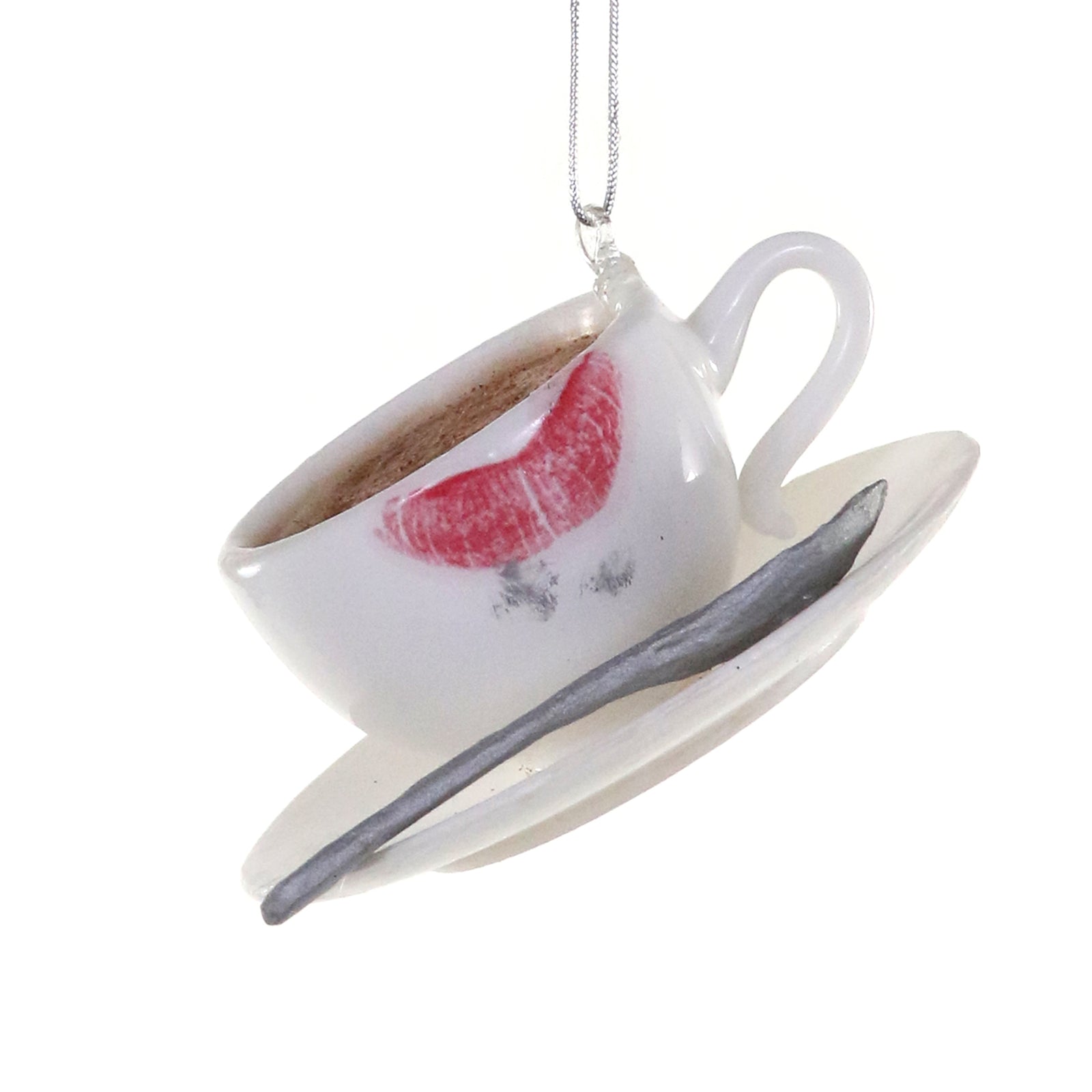 White coffee cup ornament with lipstick mark, saucer, and silver spoon.