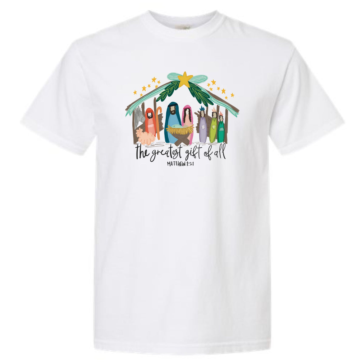 White short sleeve t-shirt with colorful nativity graphic under a star-topped stable and text reading “The Greatest Gift of All – Matthew 1:21.”