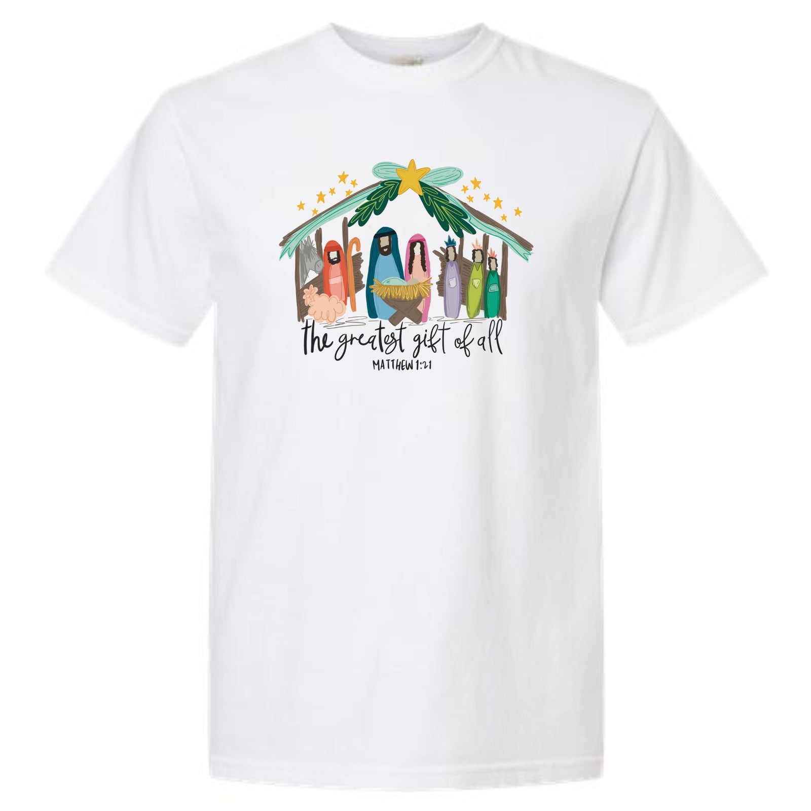 White short sleeve t-shirt with colorful nativity graphic under a star-topped stable and text reading “The Greatest Gift of All – Matthew 1:21.”