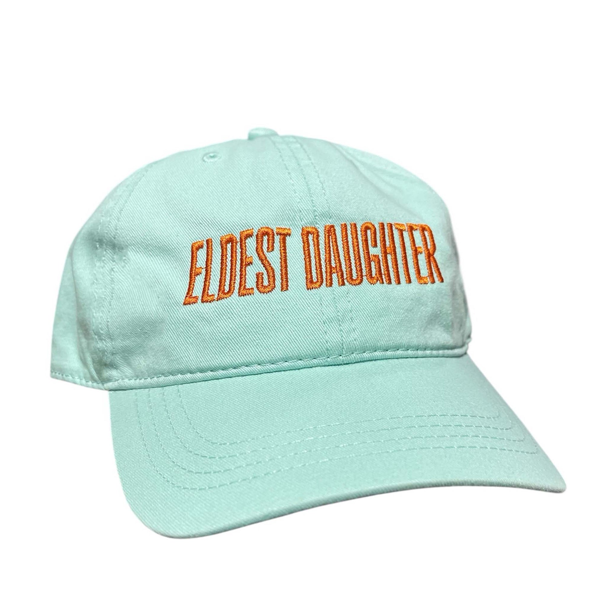 Teal baseball cap with orange embroidered text that reads “Eldest Daughter.”