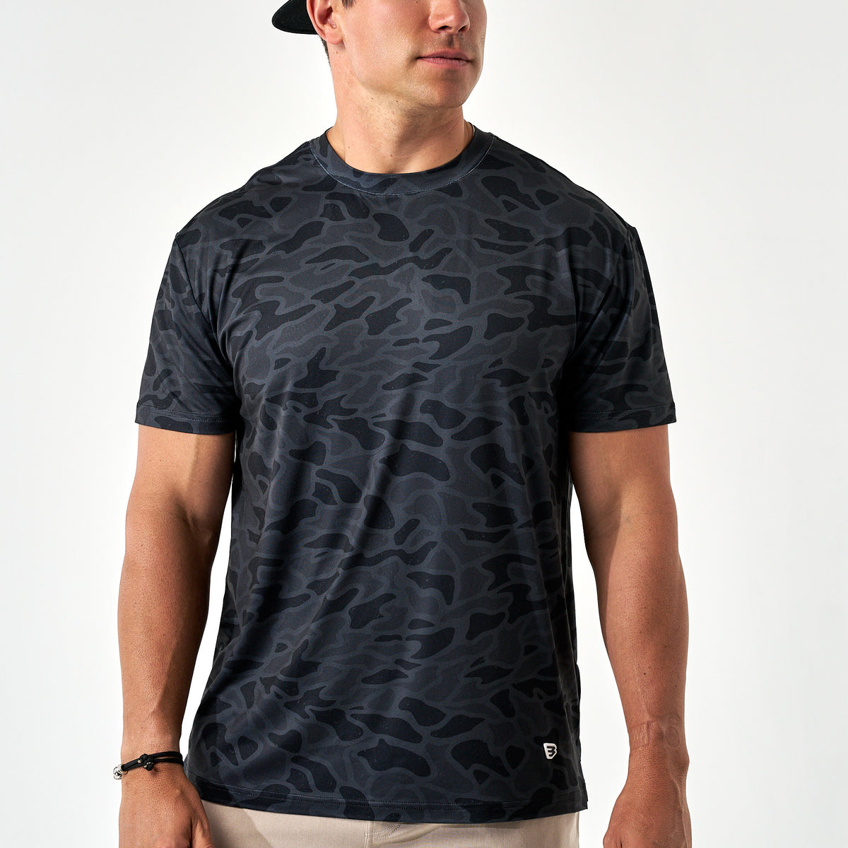 Man wearing a black camouflage t-shirt on a white background
