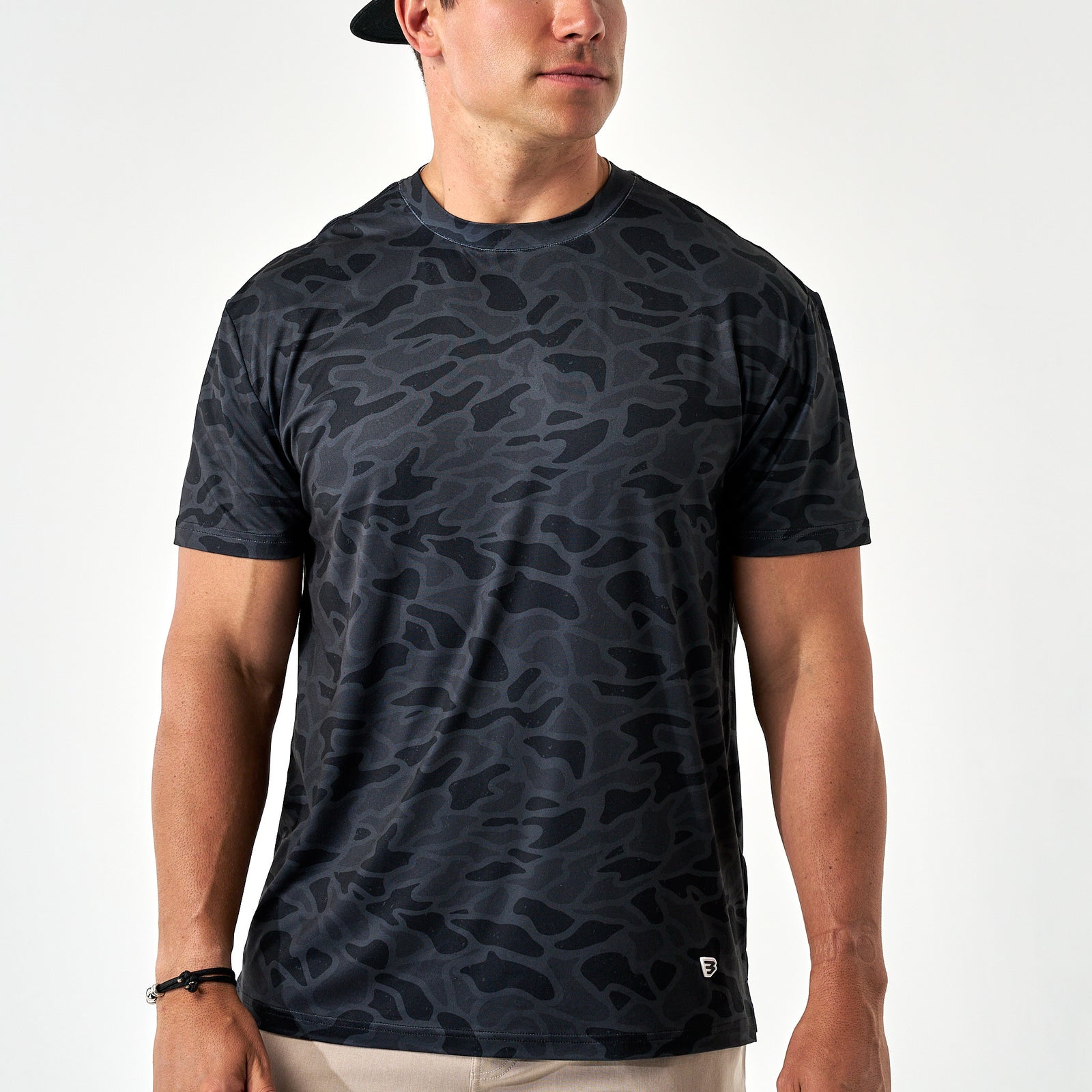 Man wearing a black camouflage t-shirt on a white background