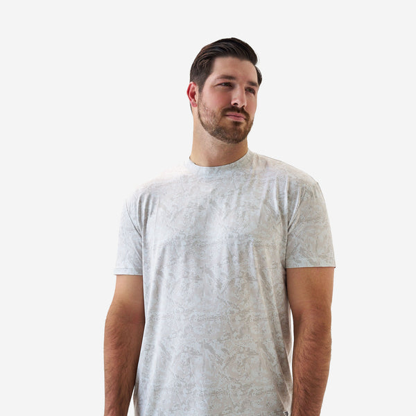 Back view of a male model wearing a light gray patterned short sleeve performance t-shirt with a subtle tonal geometric design on a white background.