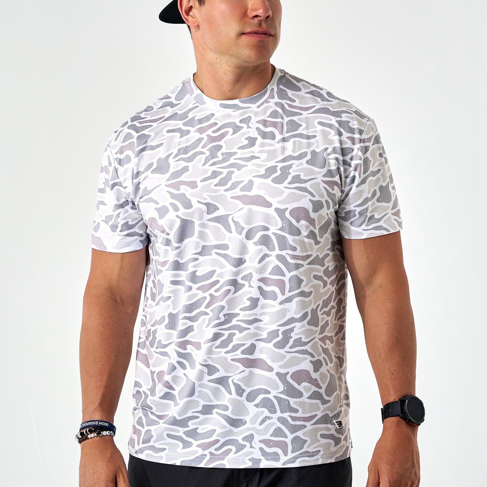 Man wearing a white camouflage t-shirt on a plain background