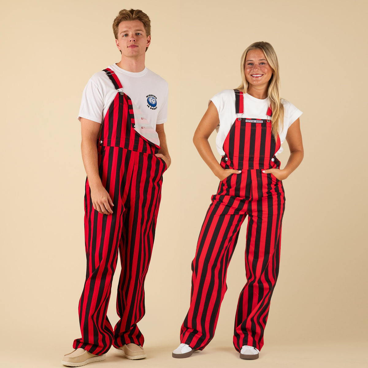 Two people wearing red and black striped overalls on a beige background