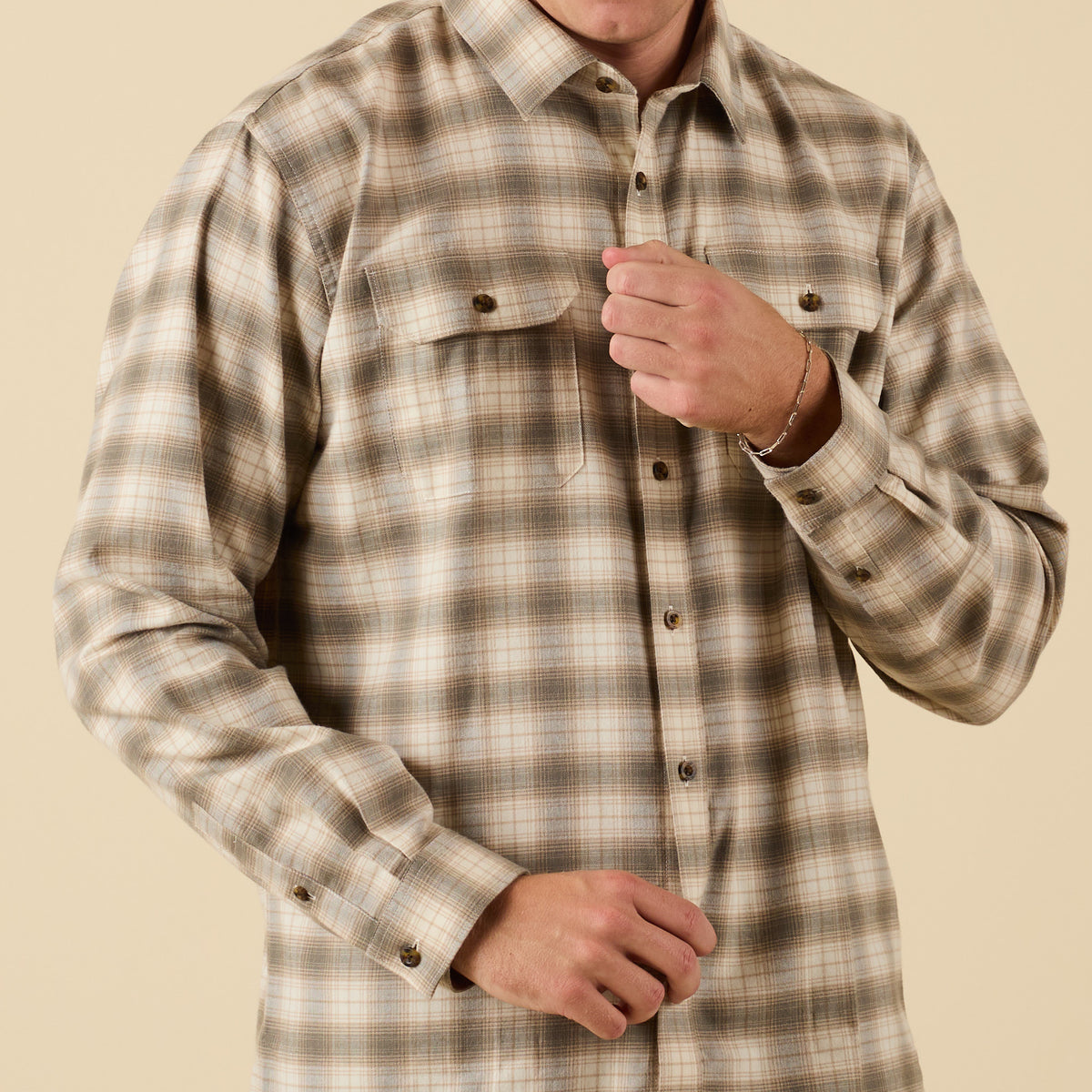 Plaid shirt worn by a person on a beige background