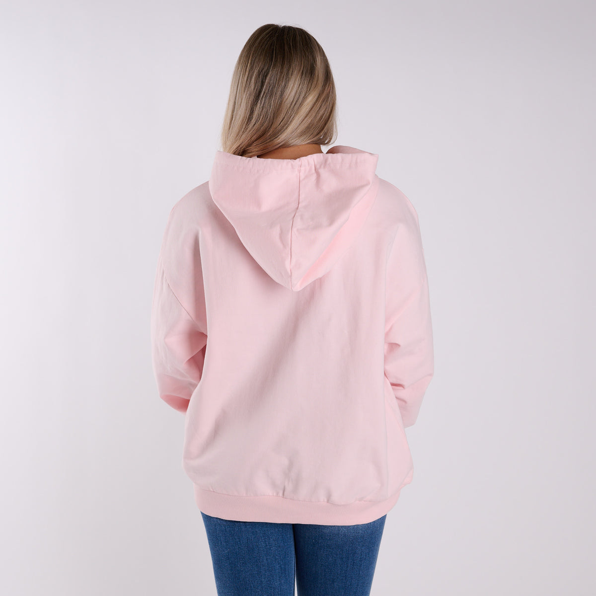 Woman wearing a pink hoodie with floral designs and subtle Simply Southern branding on a white background