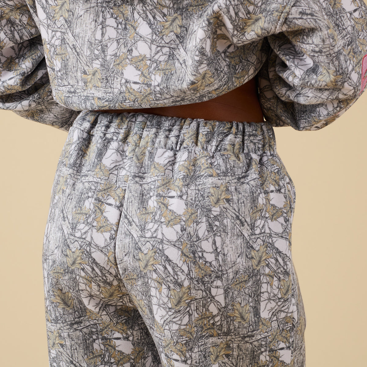 Close-up back view of camo print sweatpants with elastic waist.