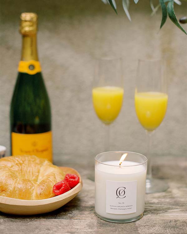 charleston candle company sunday bruch mimosa candle with a sunday brunch set up