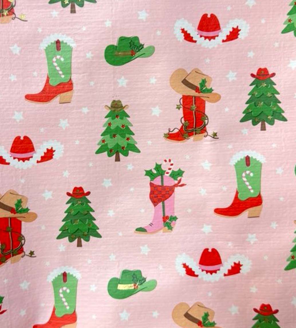 close up of swig howdy holidays print with bright red and green western themed Christmas icons on a light pink background
