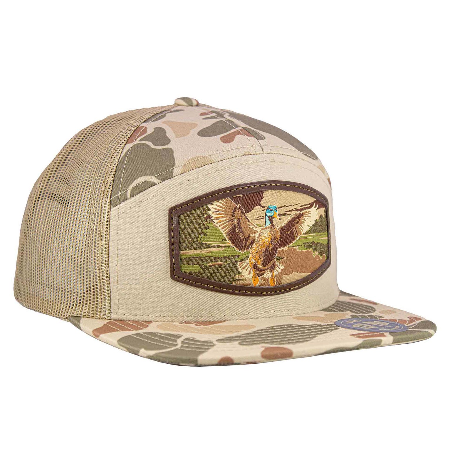 Sand camo 7-panel mesh hat with a burnished patch featuring a mallard duck in flight over a grassy wetland, flat brim and adjustable snapback.