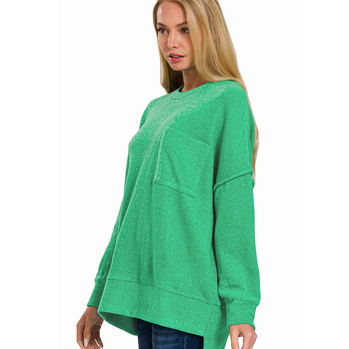 Woman wearing a green cardigan and blue jeans on a white background