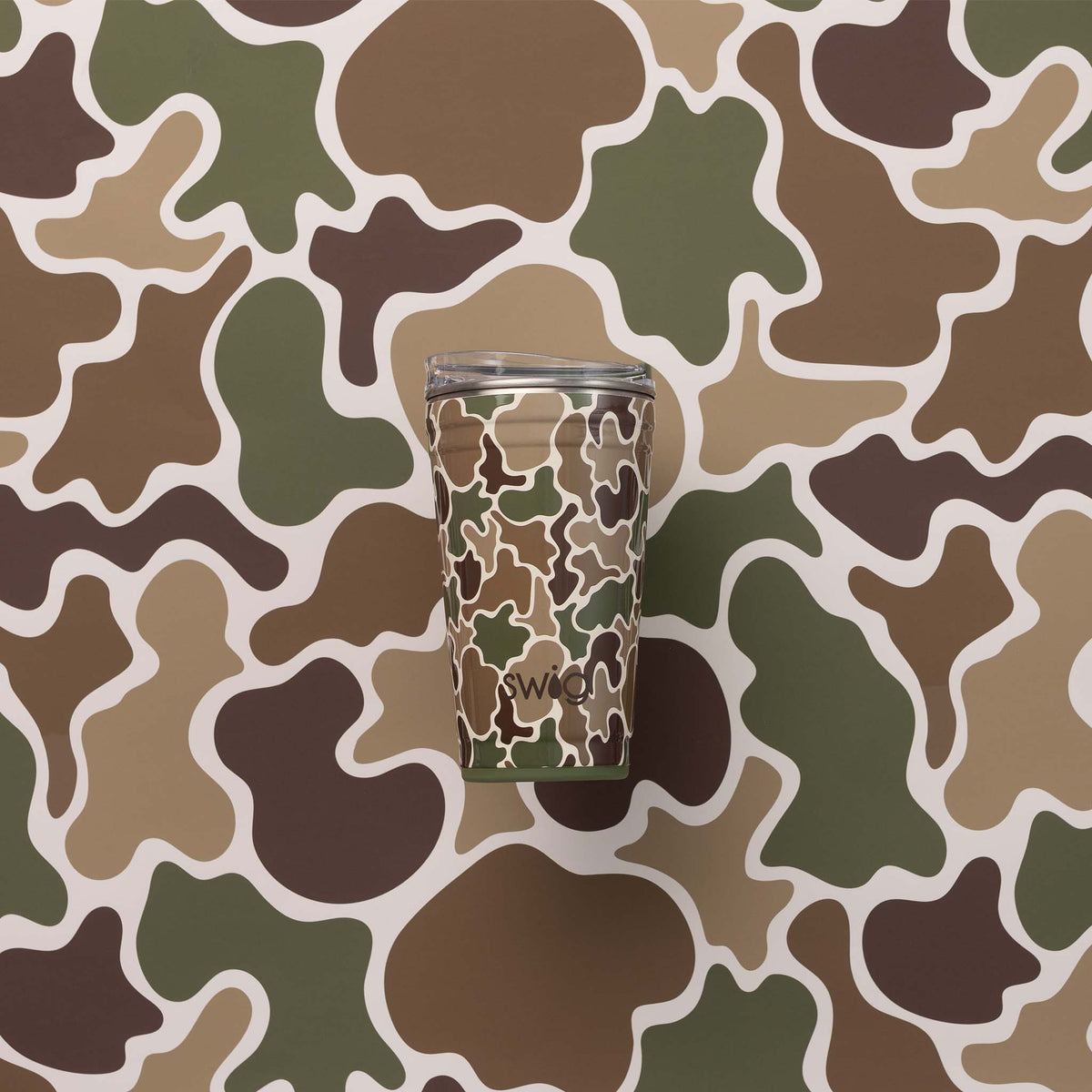 Swig Life party cup in Hunting Camo pattern placed against matching green, brown, and tan camo background.
