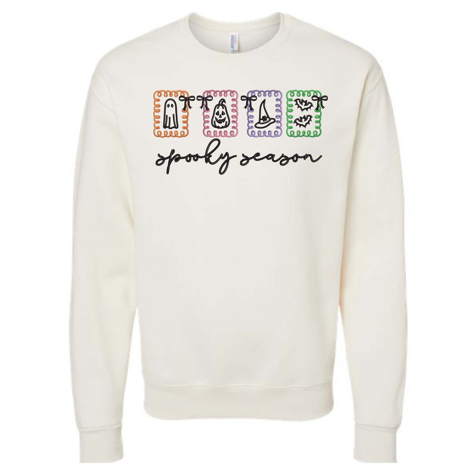 Ivory crewneck sweatshirt with colorful Halloween graphic blocks featuring ghost, candy corn, witch hat, and bats with “spooky season” text.