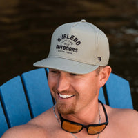 Man sitting in an adirondack chair wearing a Burlebo Outdoors hat.