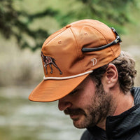 Man wearing a burnt orange colored Duck Camp hat.