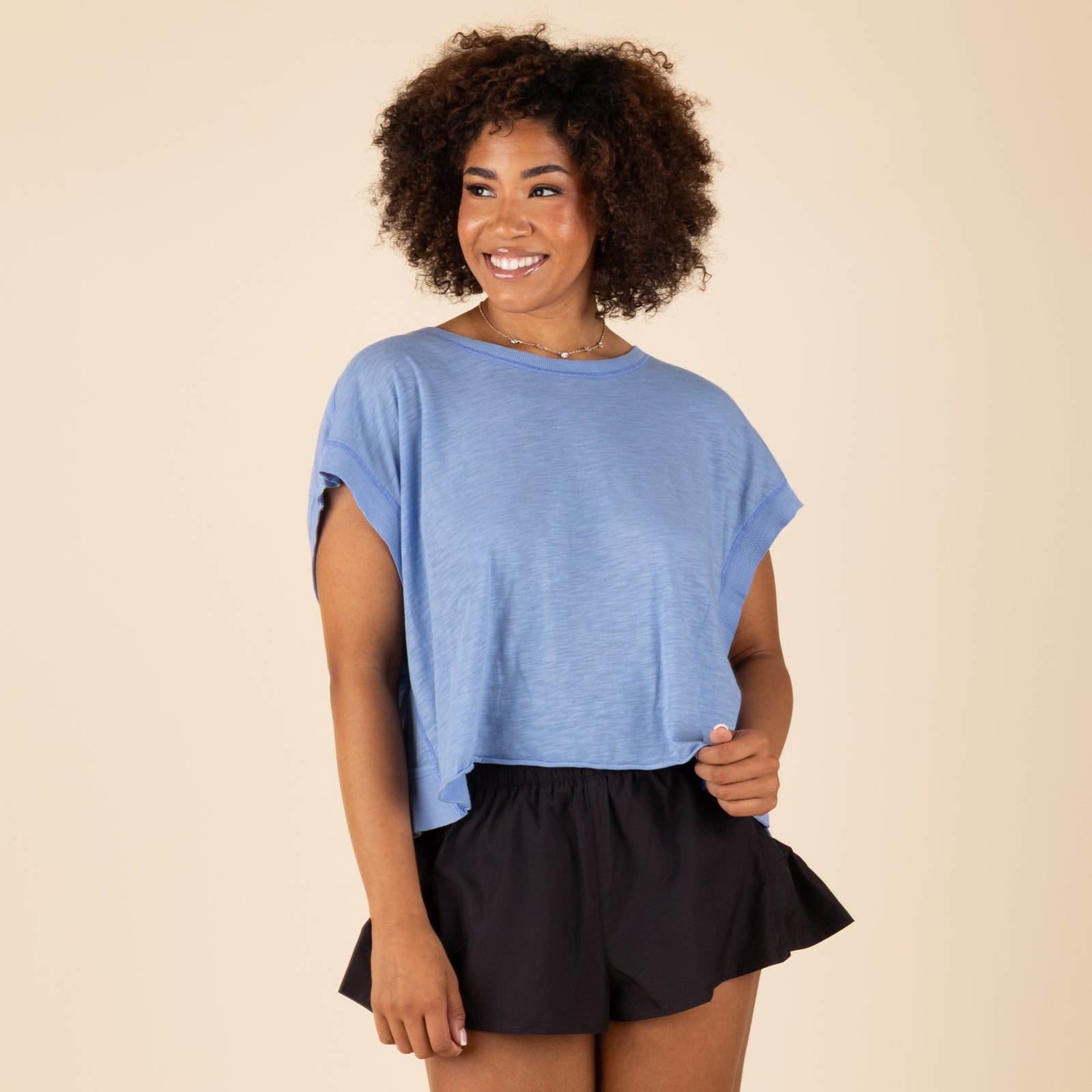 Free People Movement My Time Tee in Washed Denim, sizes XS-XL. Front view of relaxed-fit tee with cuffed short sleeves and crew neckline, paired with black shorts.