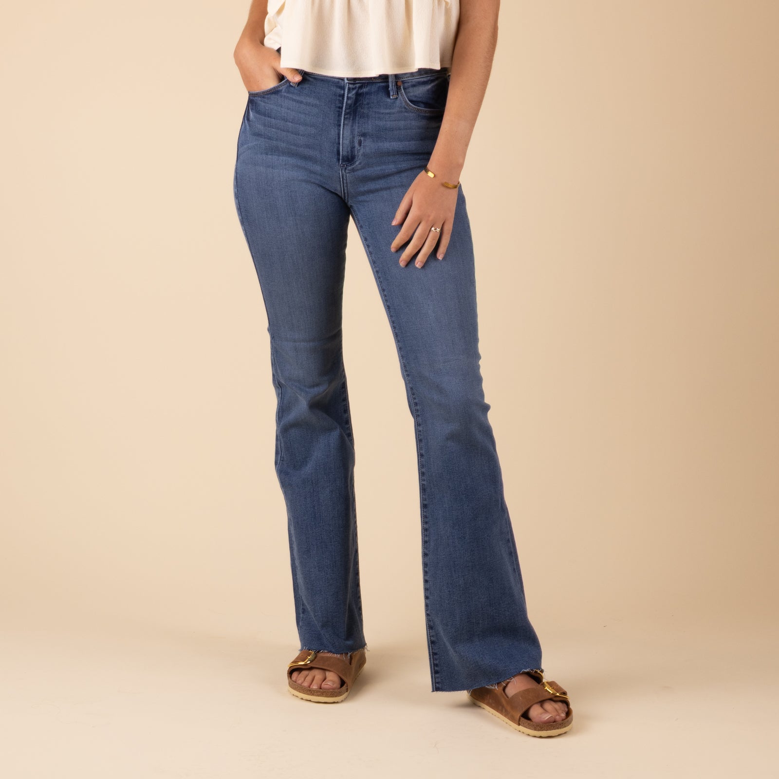 Just Black Denim Hi-Rise Scissor Flare Jeans in Medium Wash, sizes 24, 25, 26, 27, 28, 29, 30, 31.
Black denim high-rise scissor flare jeans in a medium wash, featuring a fitted waist, slim upper leg, and dramatic flared cut with raw, asymmetrical hems.