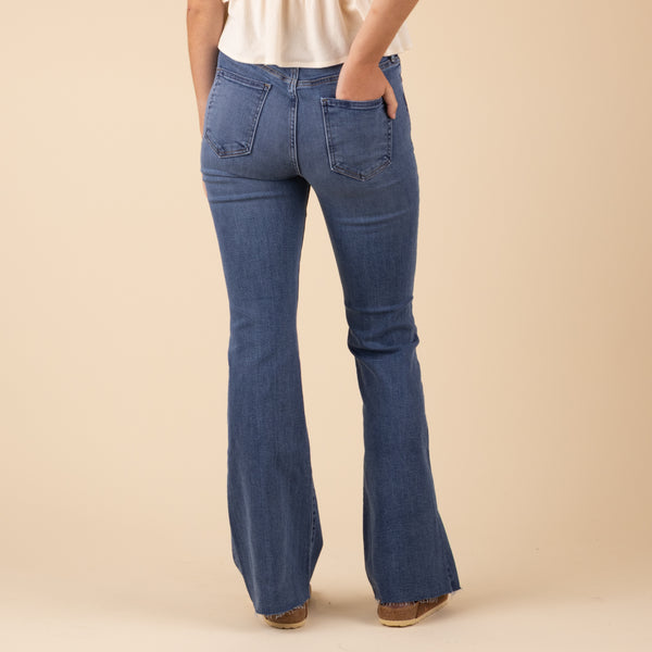 Just Black Denim Hi-Rise Scissor Flare Jeans in Medium Wash, sizes 24, 25, 26, 27, 28, 29, 30, 31.
Black denim high-rise scissor flare jeans in a medium wash, featuring a fitted waist, slim upper leg, and dramatic flared cut with raw, asymmetrical hems.
