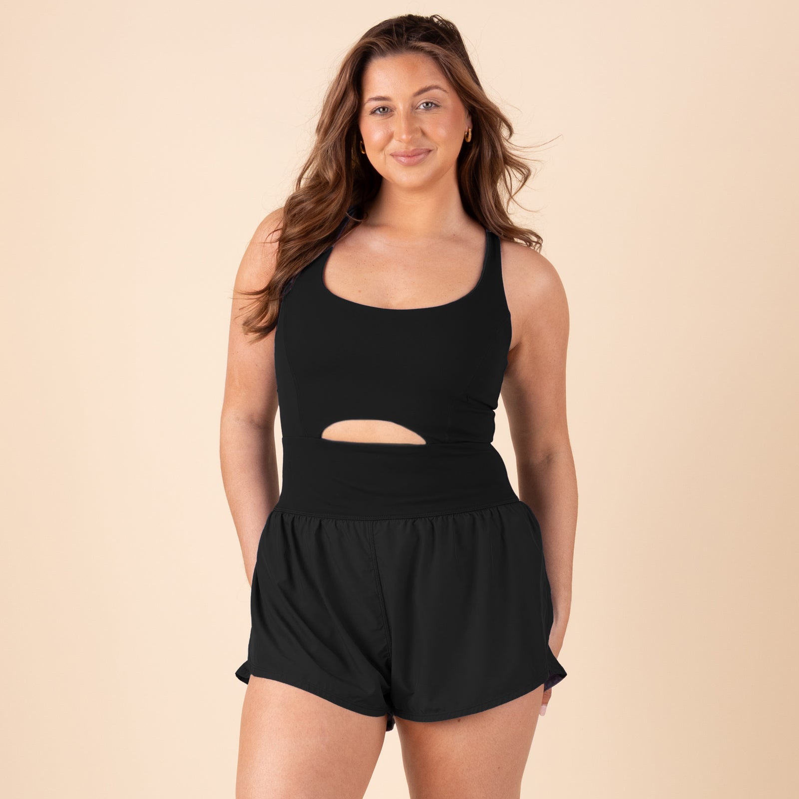 Fron view of model wearing FP movement Righteous Runsie sleeveless athletic romper in black.