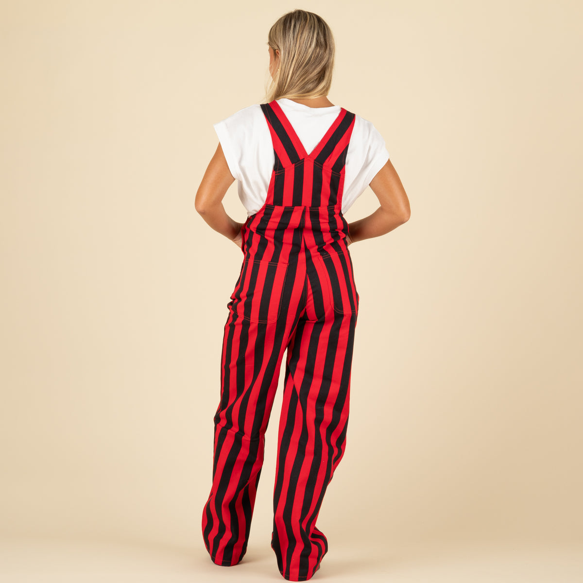 Person wearing a red and black striped jumpsuit on a beige background