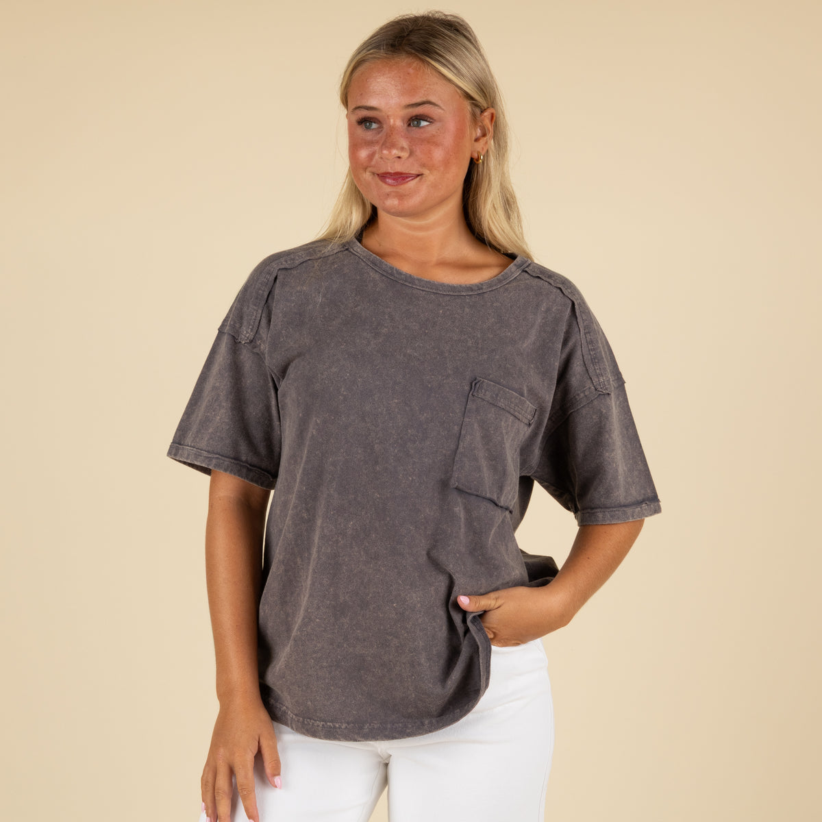 Front view of a woman in a charcoal gray oversized t-shirt with a chest pocket and washed finish.