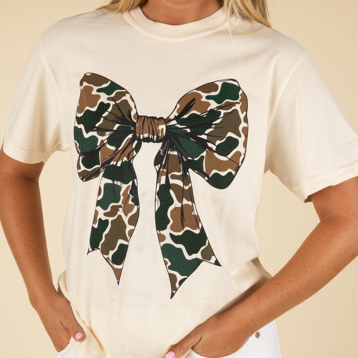 Beige t-shirt with a large camouflage bow design on a beige background