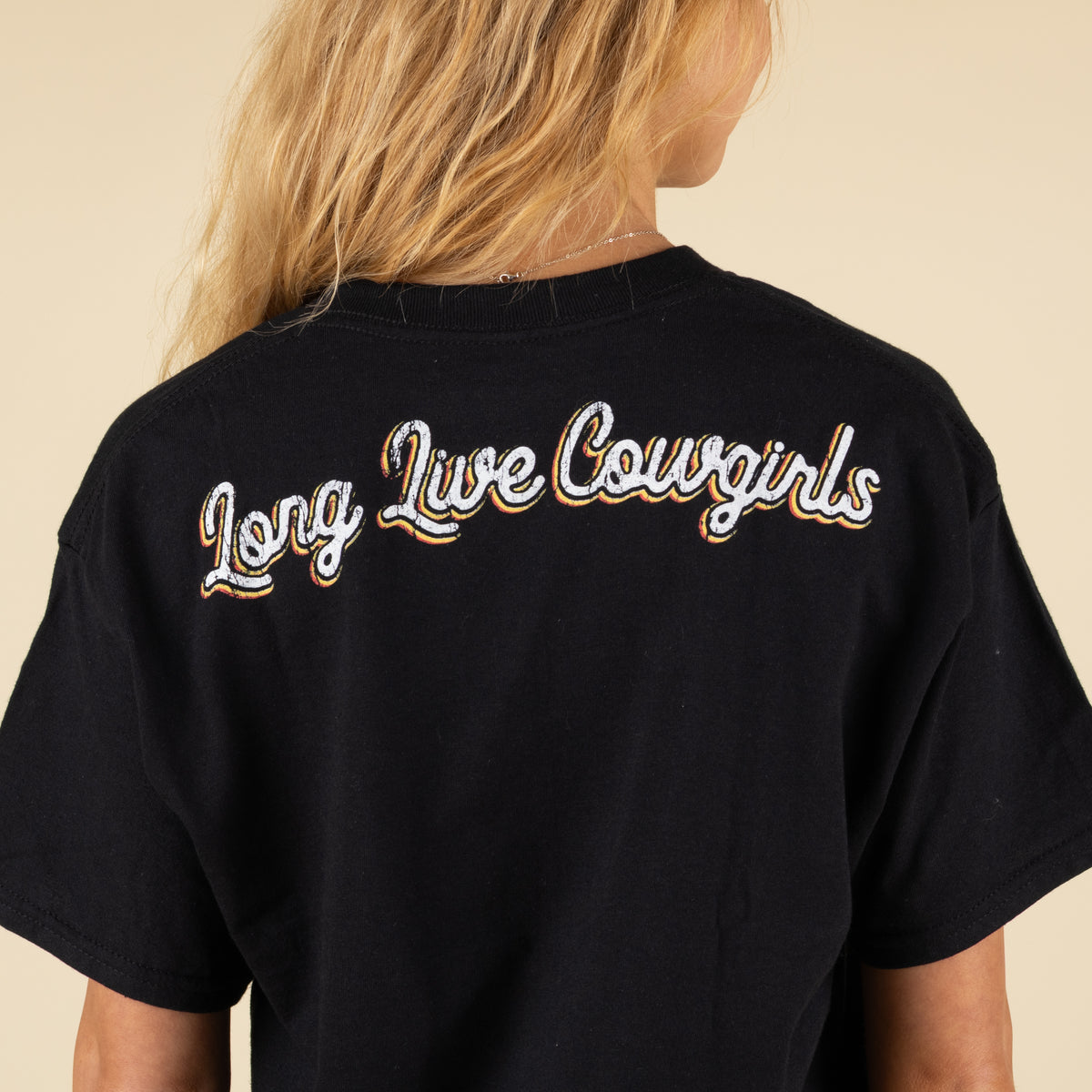 Black t-shirt with 'Long Live Cowgirls' text on the back, worn by a person.