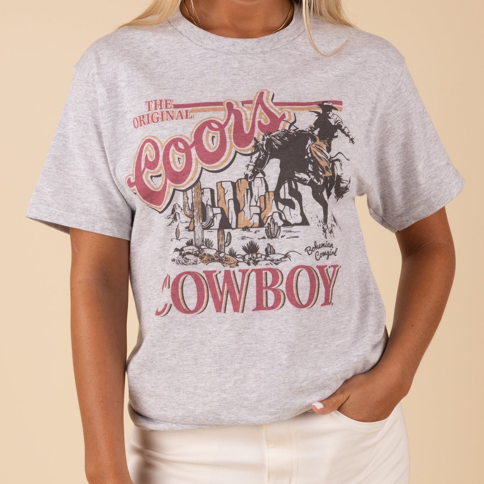 Unisex ash grey t-shirt featuring a bold 'Coors Cowboy' graphic on the front. The shirt has a classic crew neckline, short sleeves, and a relaxed fit, styled in a casual western theme.