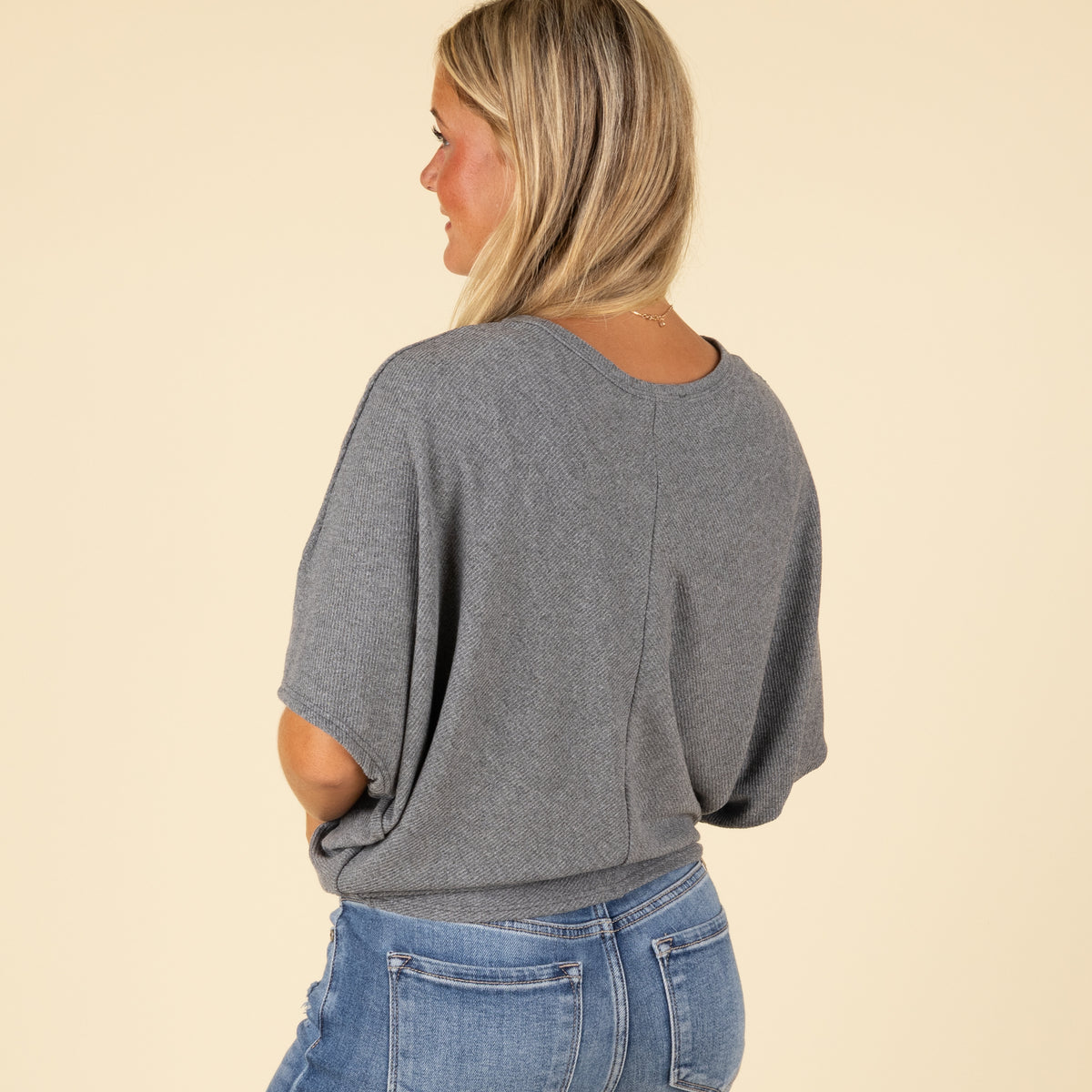 Close-up side view of grey cocoon top’s ribbed sleeve and soft texture.