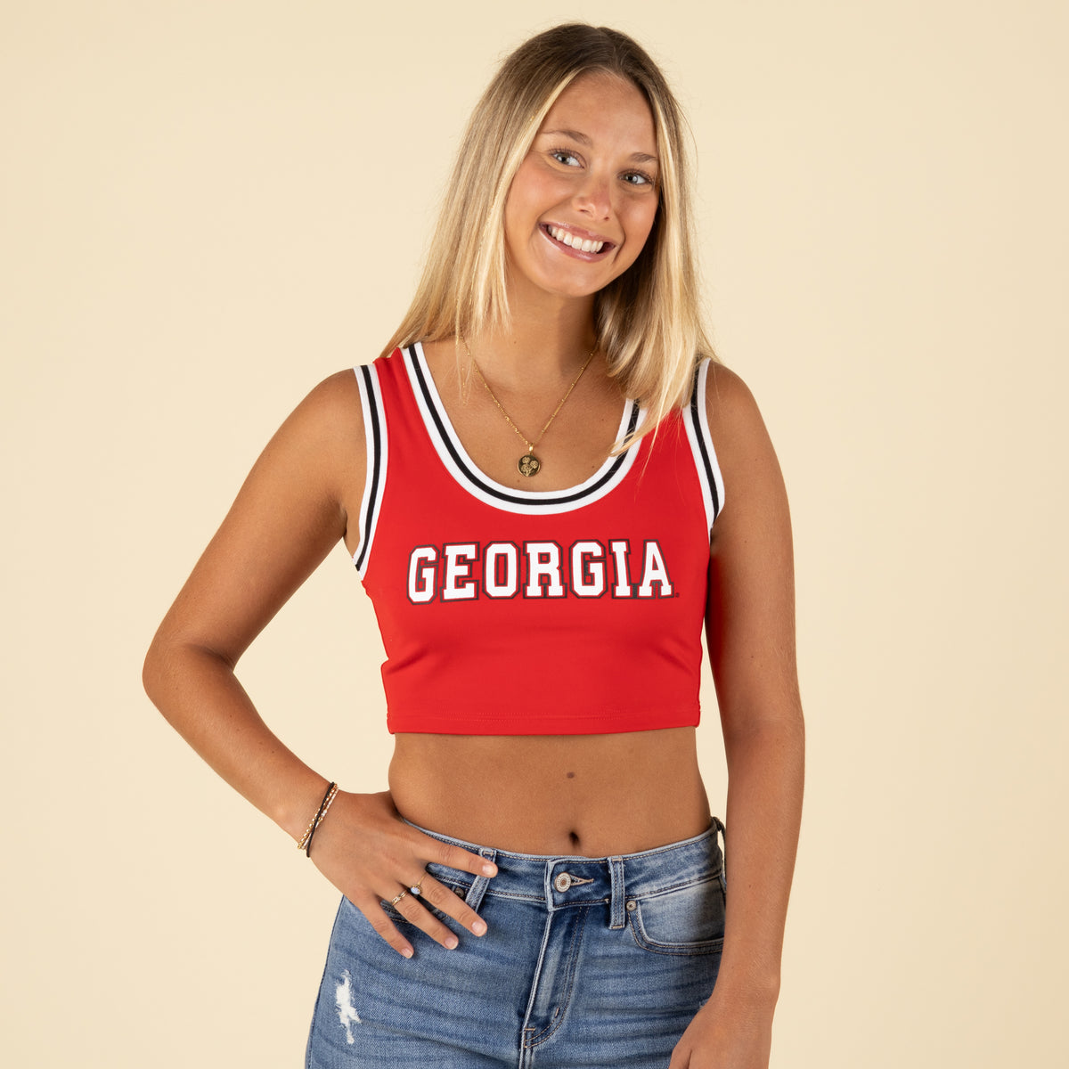 Woman smiling in red Georgia V-neck crop top with striped neckline and Georgia text.