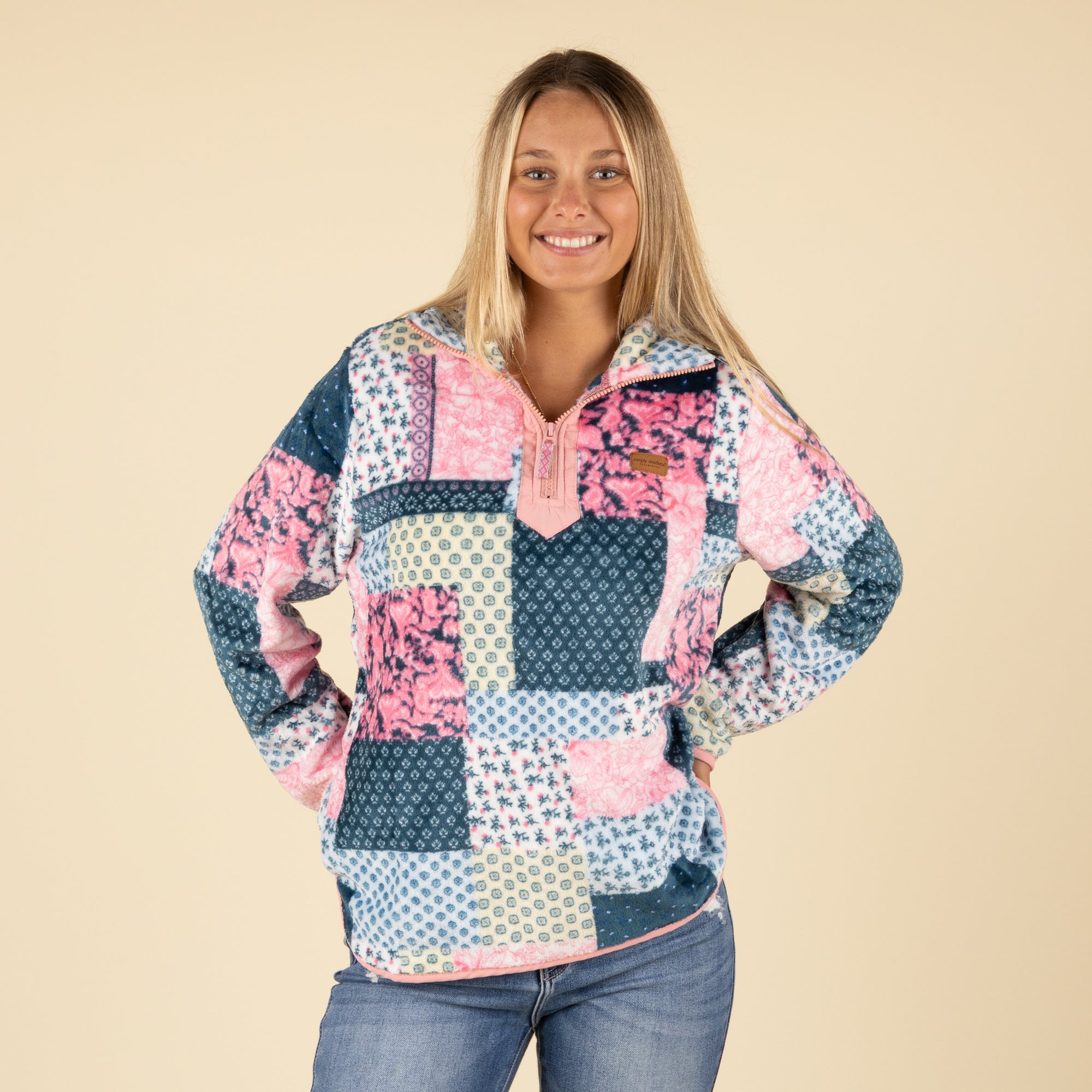 Front view of Simply Southern patchwork fleece pullover with quarter-zip neckline, pink trim, and multicolor design.