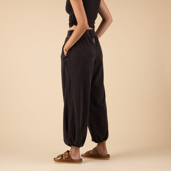  Woman Wearing Free People Movement Hot Shot Crossover Set, color black, sizes XS-L, machine washable, 95% cotton, 5% elastane
Soft, jersey fabrication; relaxed fit; cropped muscle tee top with seaming detail; ankle length pant with high-rise waist and wide leg; elasticated waistband and cuffs; crossover detail on top; ribbed collar; side seam pockets