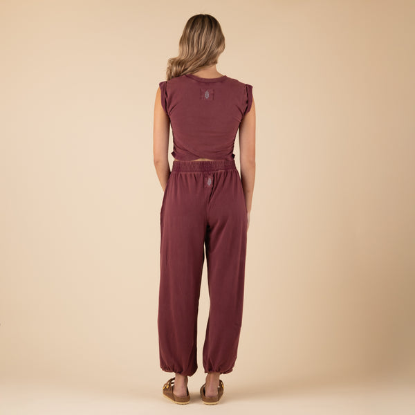 Woman Wearing Free People Movement Hot Shot Crossover Set, color clove, sizes XS-L, machine washable, 95% cotton, 5% elastane
Soft, jersey fabrication; relaxed fit; cropped muscle tee top with seaming detail; ankle length pant with high-rise waist and wide leg; elasticated waistband and cuffs; crossover detail on top; ribbed collar; side seam pockets