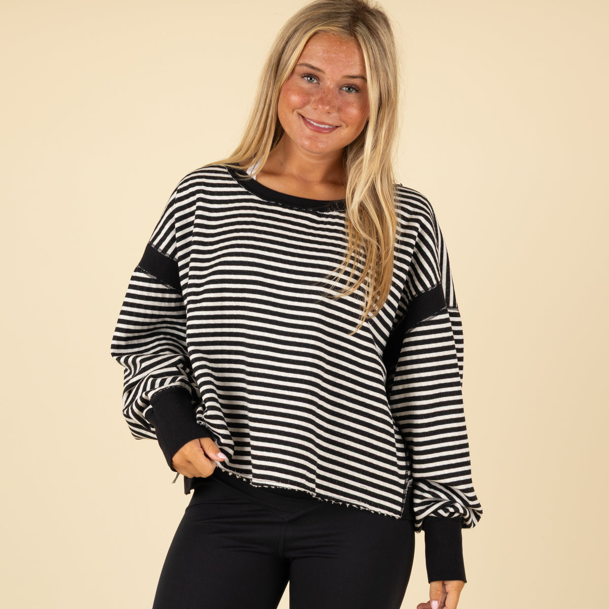 Black and white striped long-sleeve top with black cuffs and neckline, shown from the front with a relaxed fit.