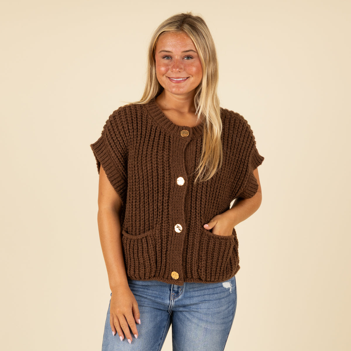 Front view of women’s brown chunky knit short sleeve button-front top with gold buttons and front pockets.