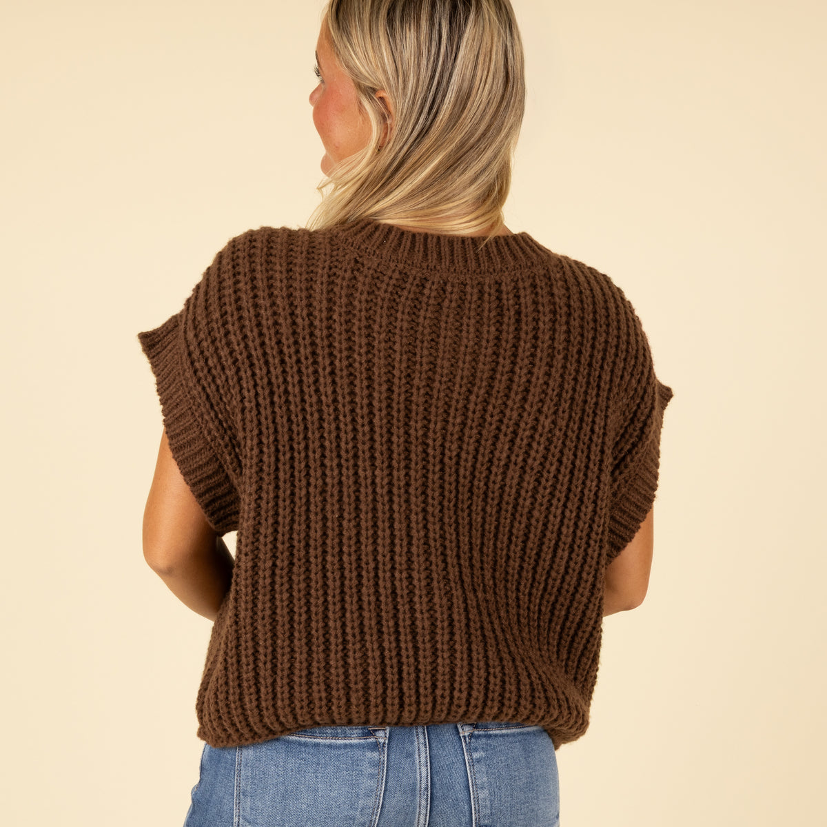 Back view of women’s brown chunky knit short sleeve button-front top with ribbed knit design.