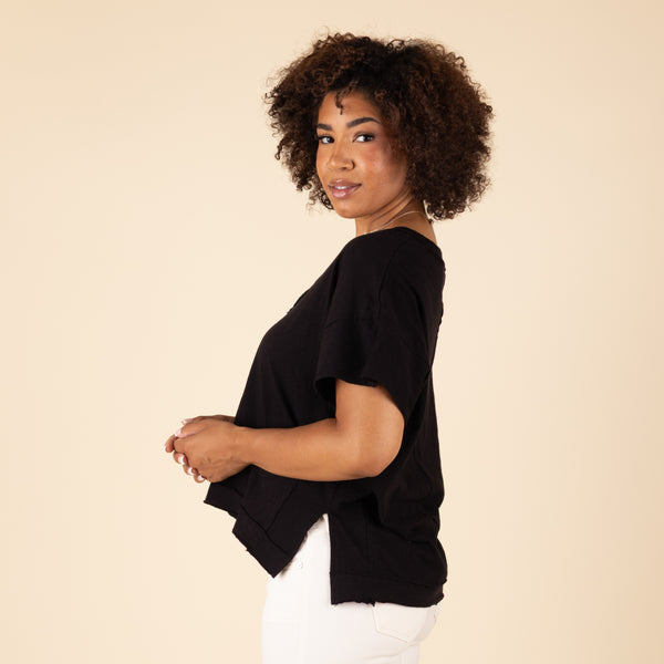  Woman wearing a black top against a beige background