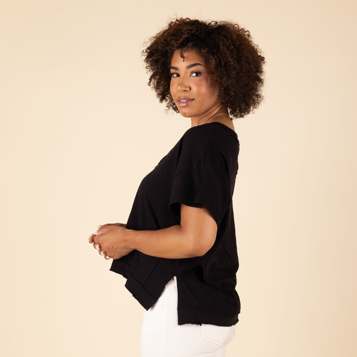 Woman wearing a black top against a beige background