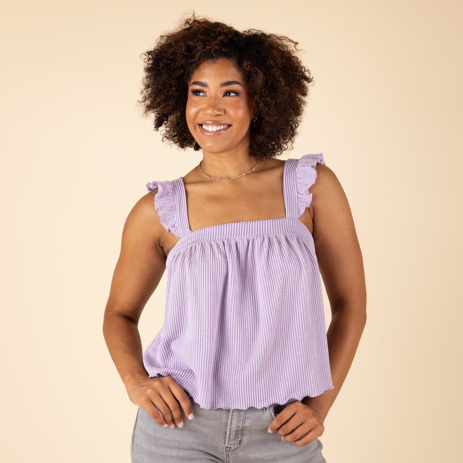 Lavender sleeveless babydoll top with ruffle straps and square neckline, modeled from the front.