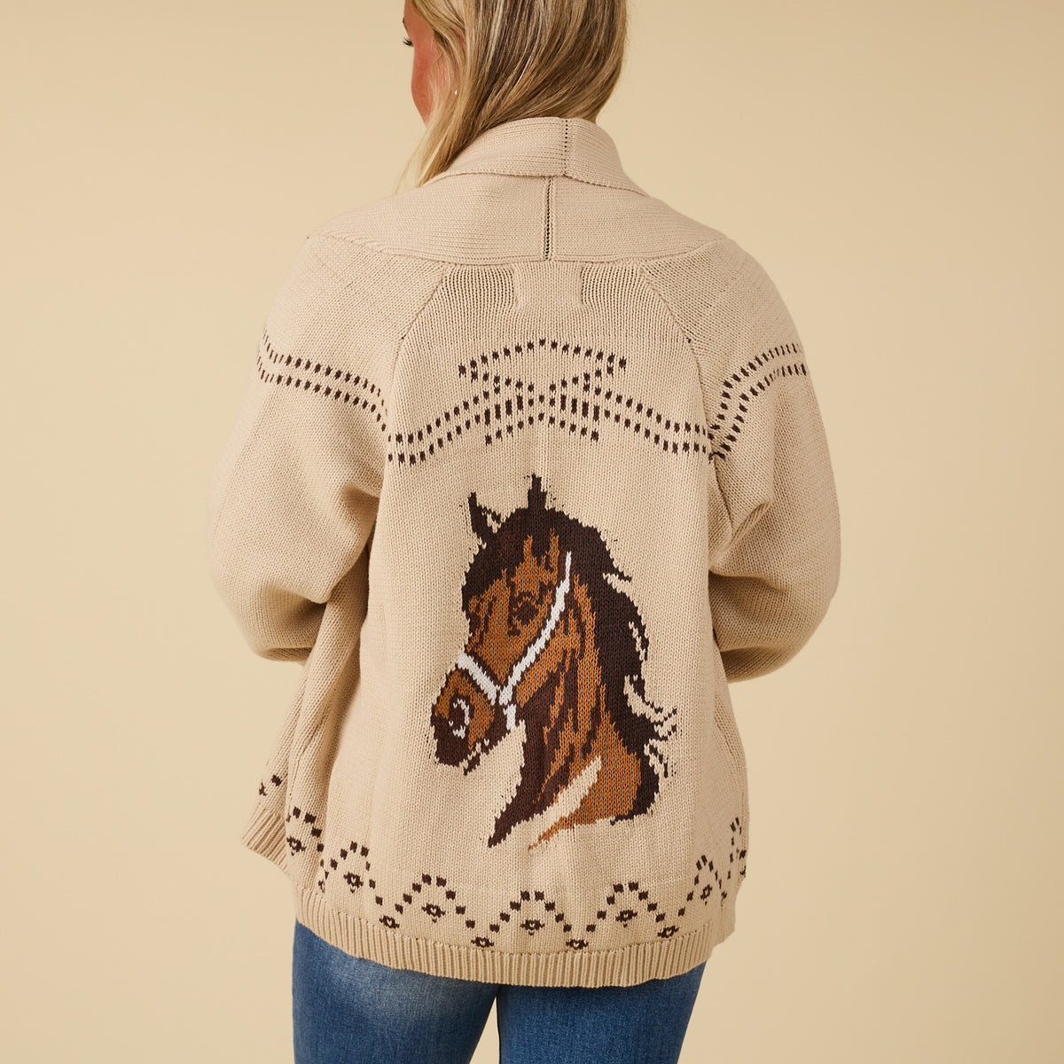 Back view of ivory knit cardigan featuring large horse head graphic and stitched western-inspired details.