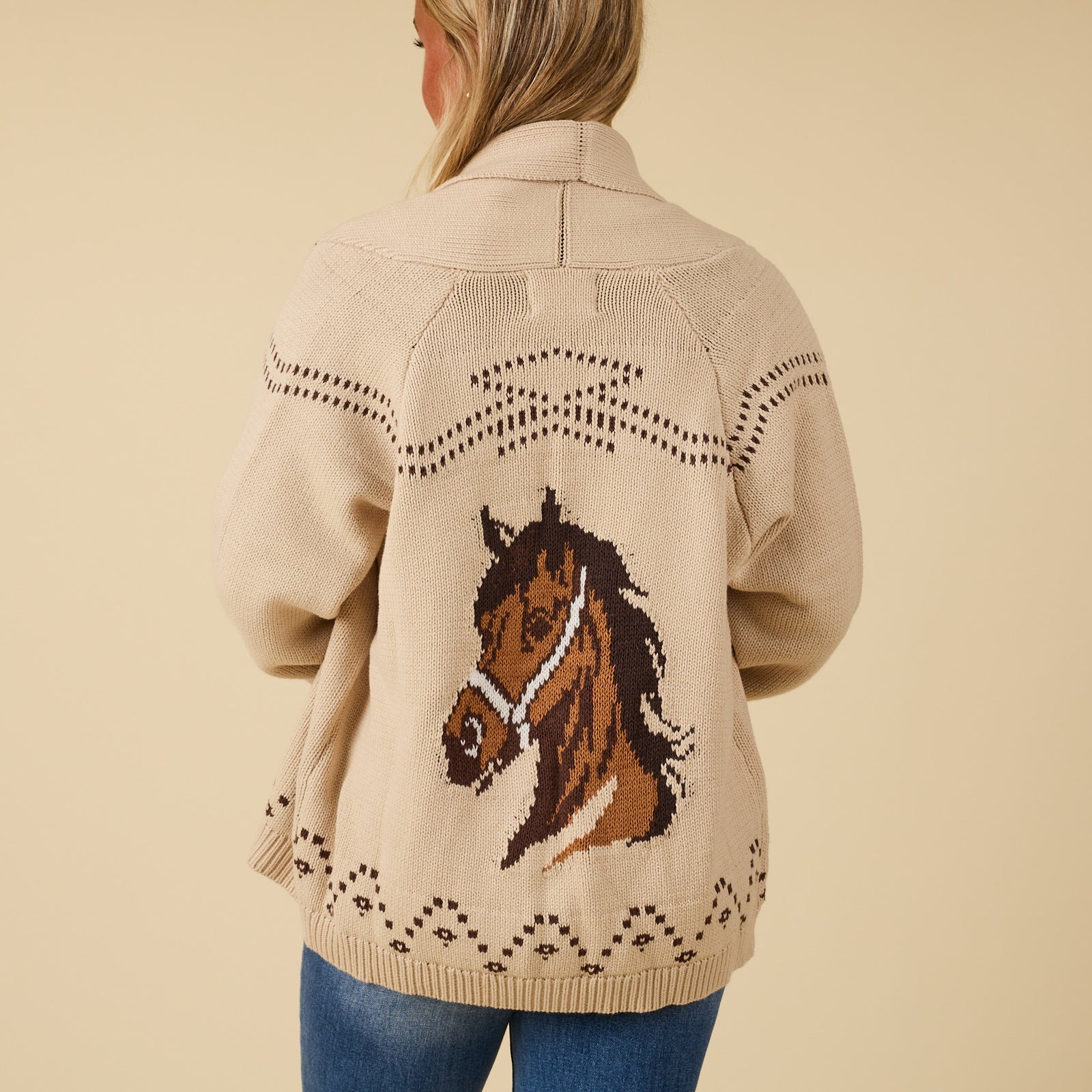 Back view of ivory knit cardigan featuring large horse head graphic and stitched western-inspired details.