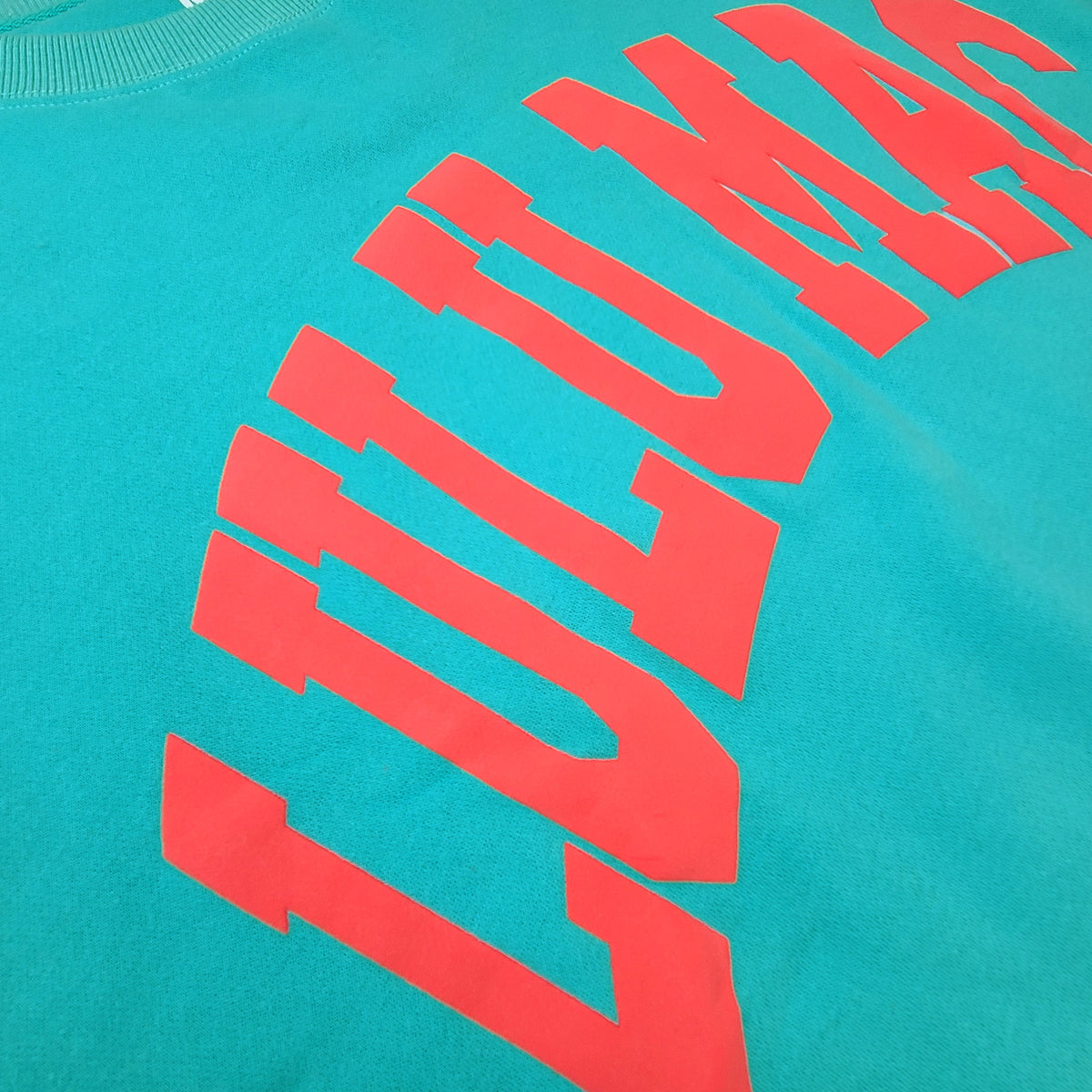 youth teal lulumac sweatshirt with coral lettering across the chest.