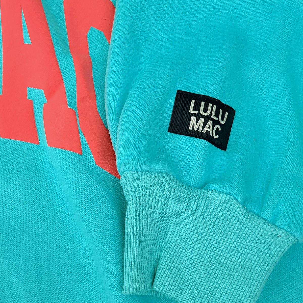 Teal sweatshirt with red text and a black 'LULU MAC' label