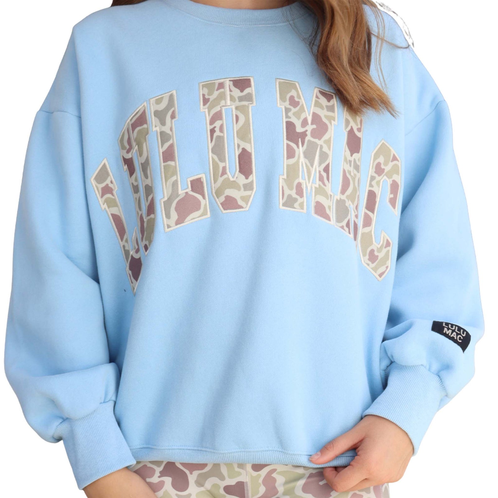 Light blue Youth sweatshirt with 'LULU MAC' camo print across the front chest shown on a white background