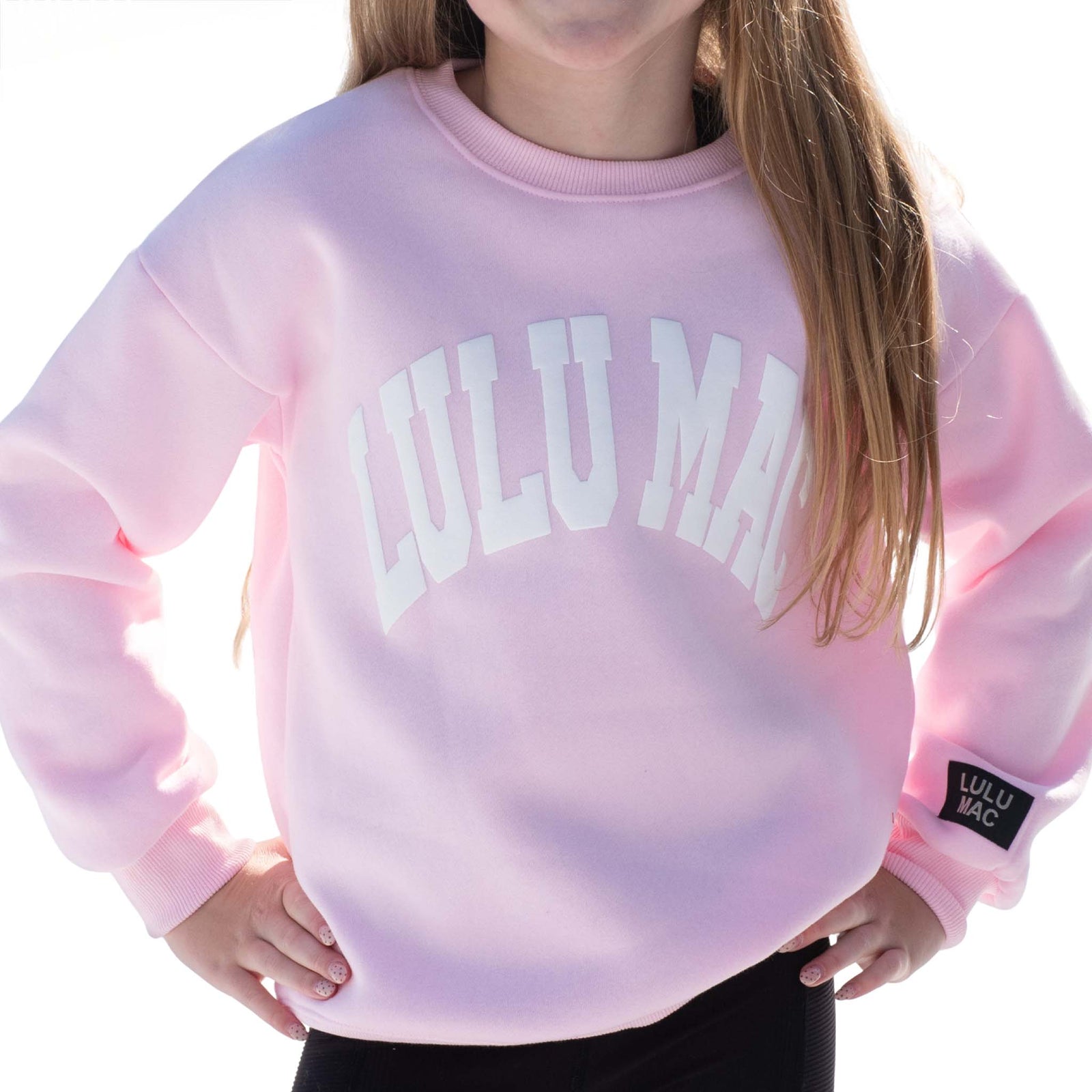Pink sweatshirt with 'LULU MAC' branding worn by a person.
