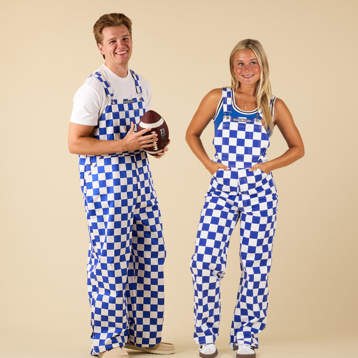 Two people wearing blue and white checkered overalls on a beige background