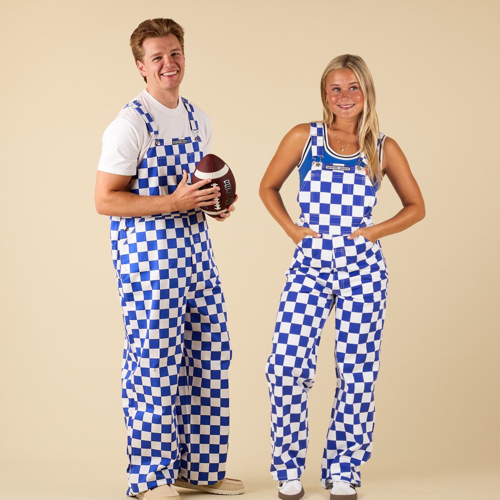 Two people wearing blue and white checkered overalls on a beige background