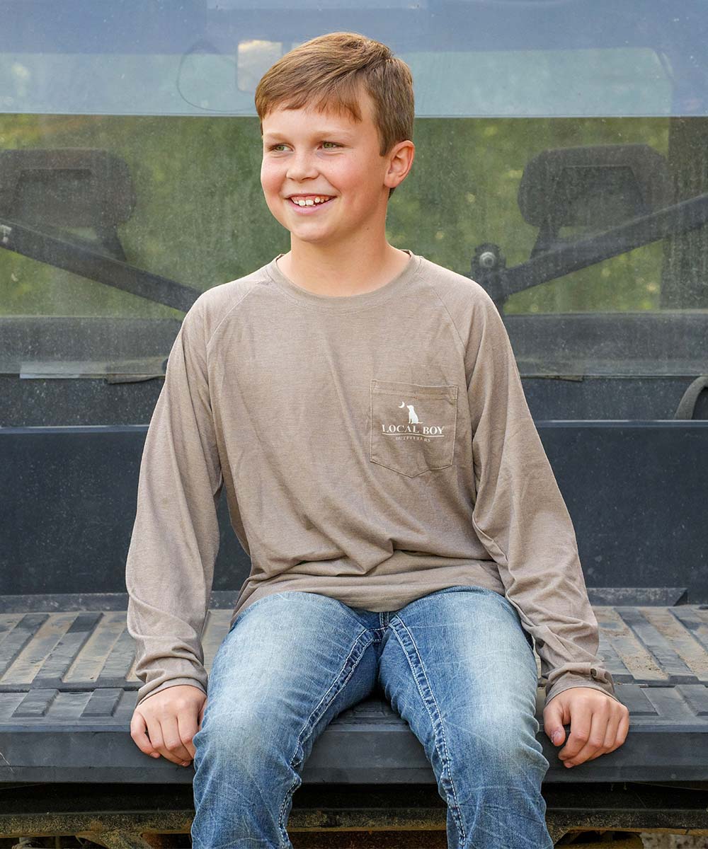 young boy sitting on the back of an ATV.